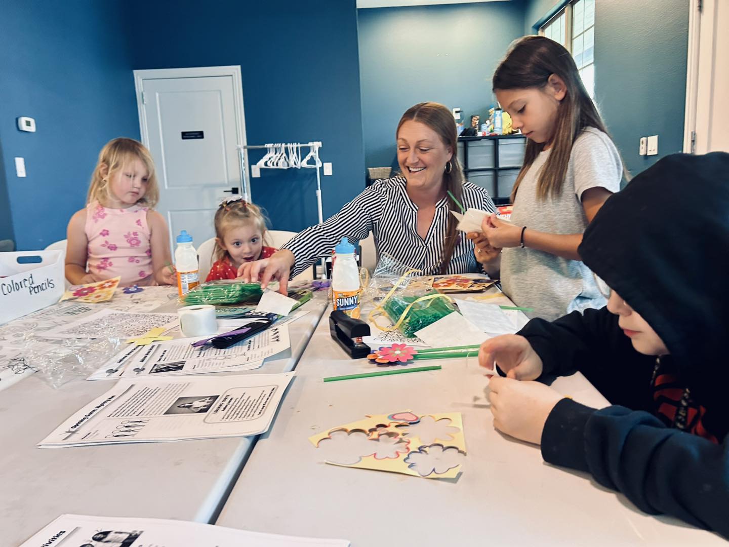 Children creating crafts with a church volunteer