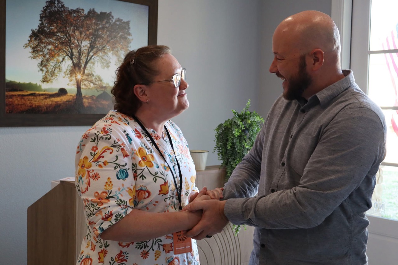 Two people sharing a warm welcome at church